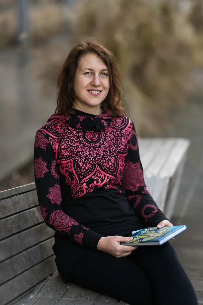 Koučka Veronika se dívá do záběru, v ruce drží zápisník